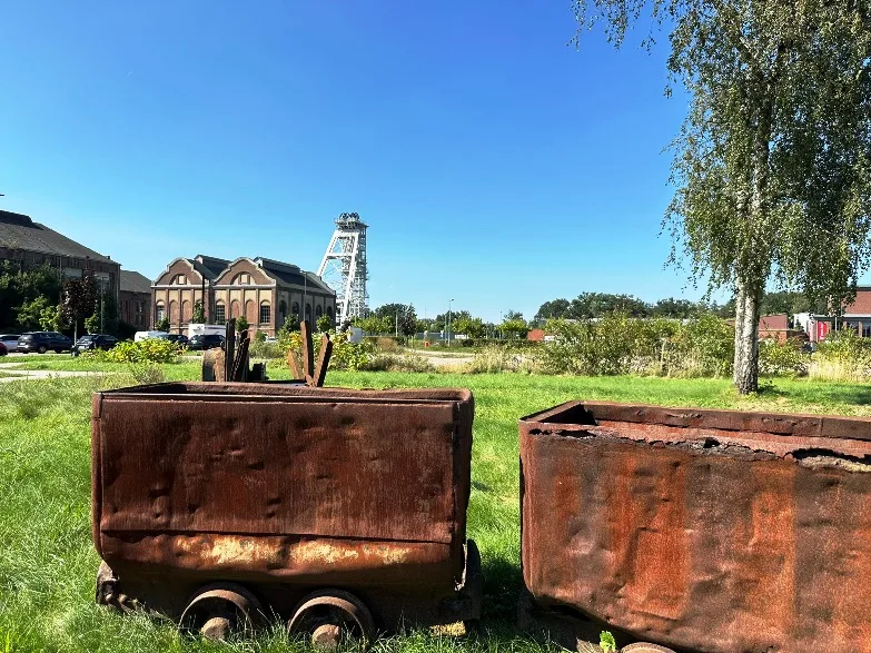 Verrostete Kohlewagen vor der ehemaligen Zeche Fürst Leopold in Dorsten, im Hintergrund die historische Industrieanlage