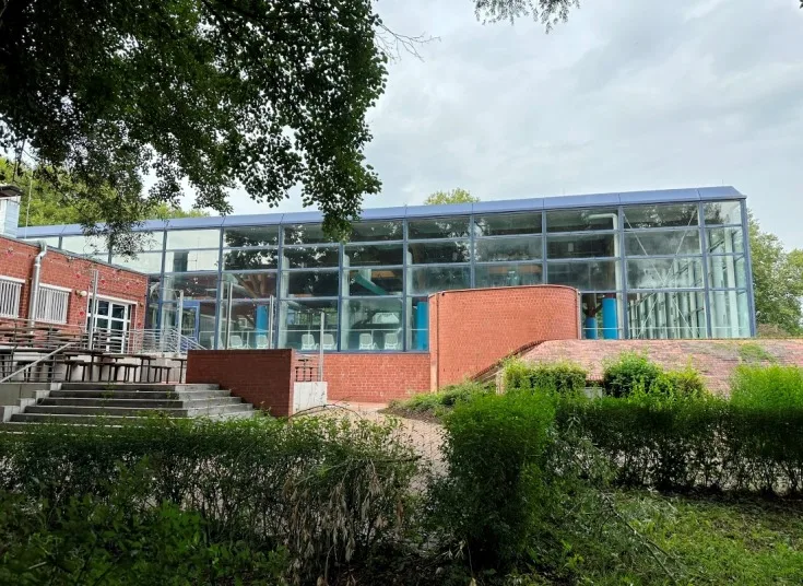 Schwimmbad Wulfen in Dorsten - Blick auf die Rückseite der Schwimmhalle des Schwimmbads Wulfen in Dorsten. Die glatten Wände und großen Fensterflächen sorgen für eine moderne Optik und lassen viel Tageslicht ins Innere.